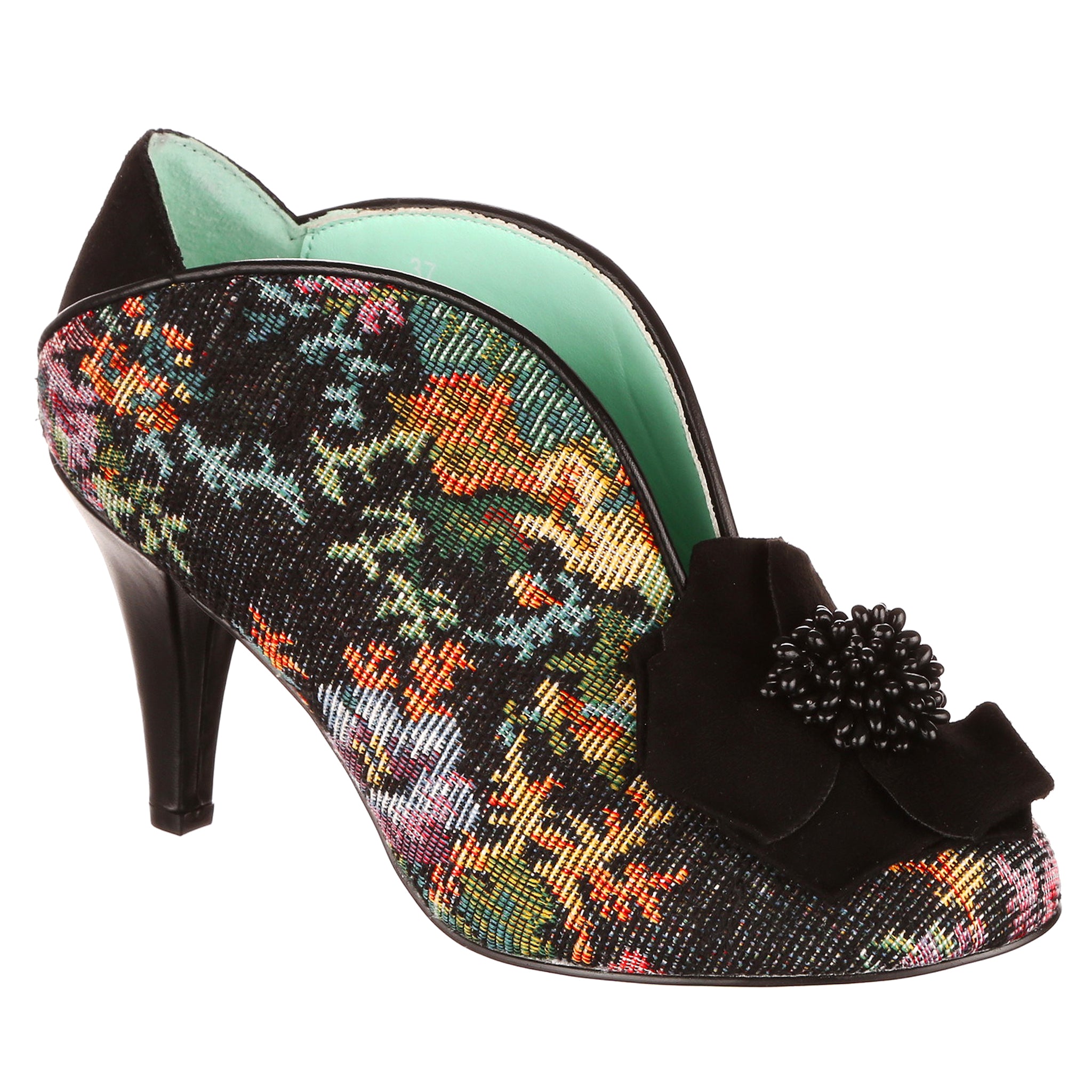 Multi-coloured floral tapestry high-heeled shoe with black decorative bow on the toe on a white background