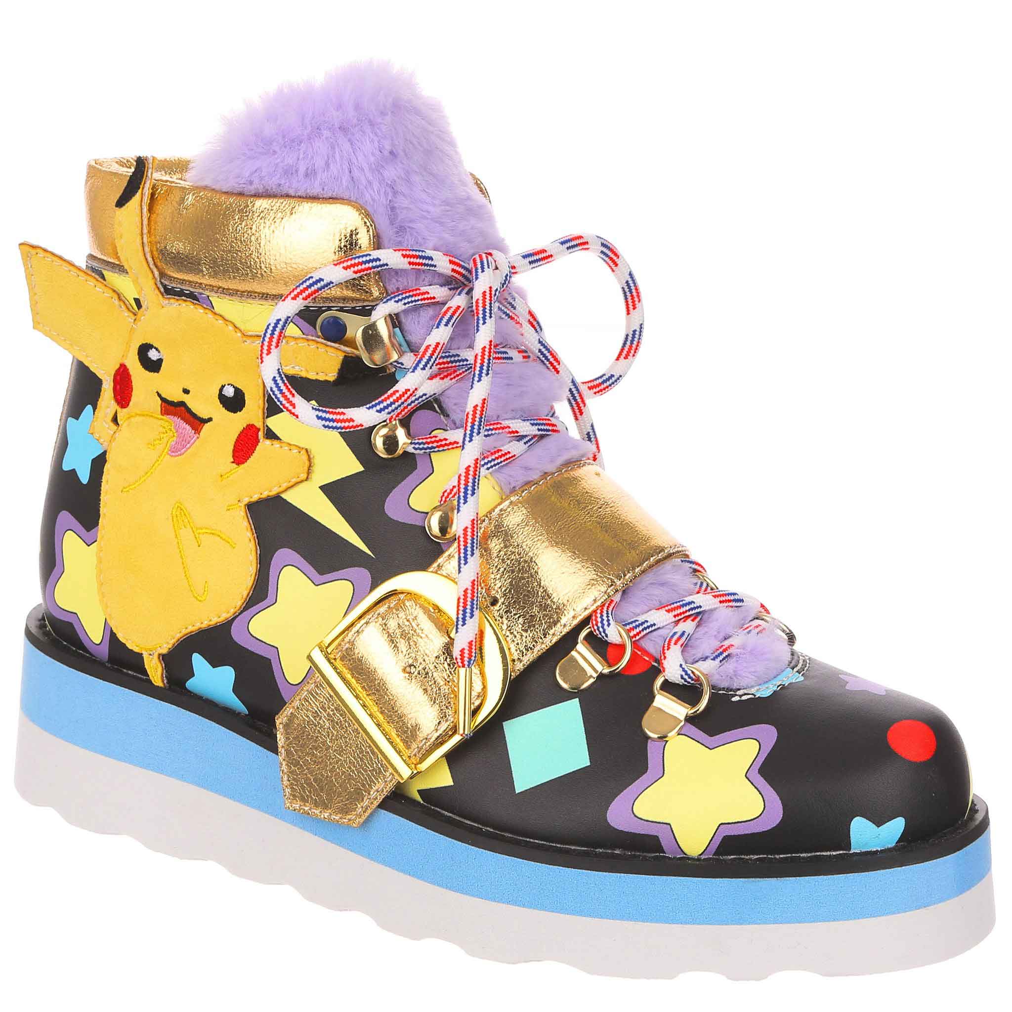 Black lace up ankle walking boot with blue and white platform, decorated with colourful stars and shapes and an applique of Pokemon character Pikachu. A gold strap crosses over the laces and the fluffy purple tongue.