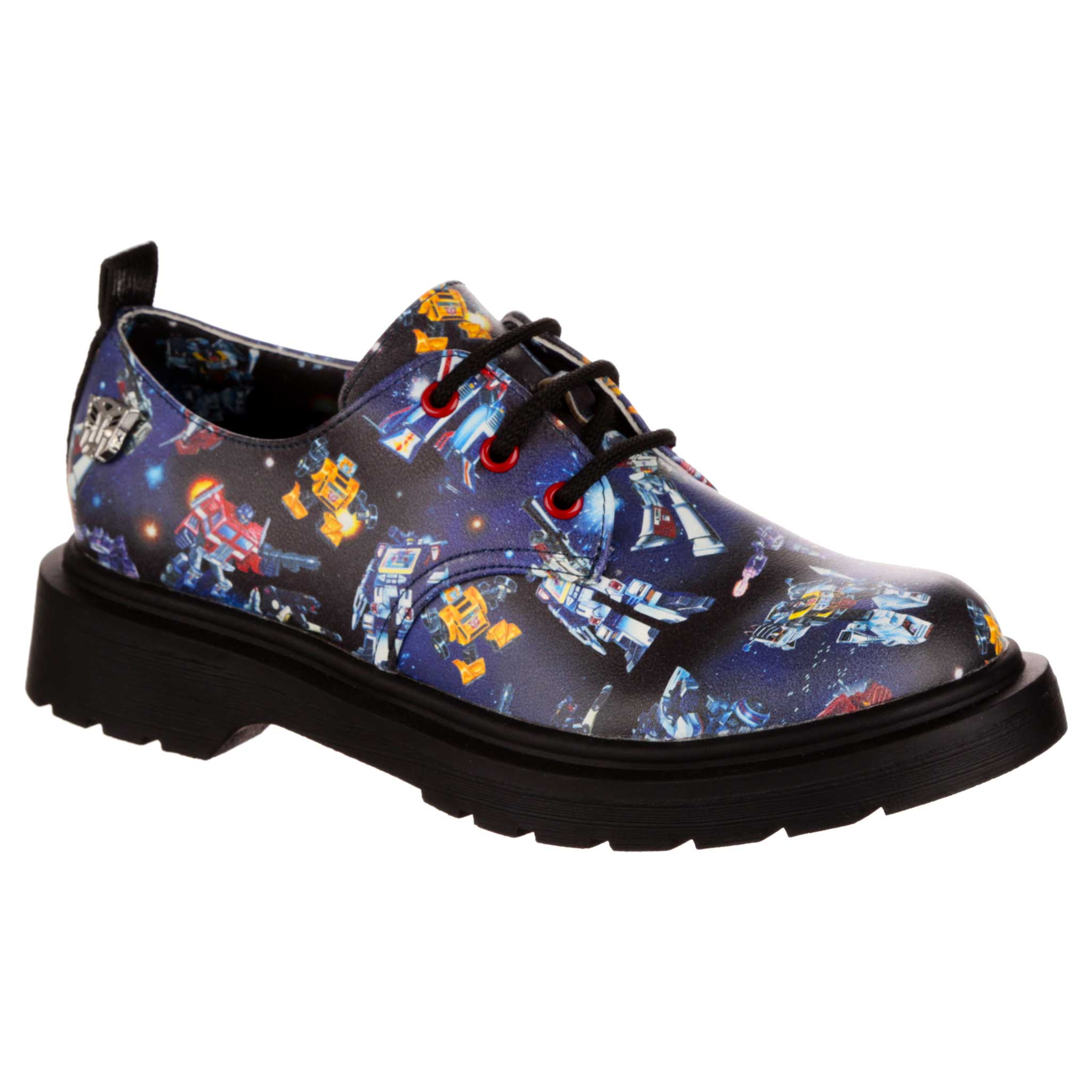 A dark blue flat loafer style shoe with black laces, red eyelets and a black chunky sole. An eighties comic strip print depicting a Transformers battle in space covers the shoe with a blue Transformers lining and pull on tab. 