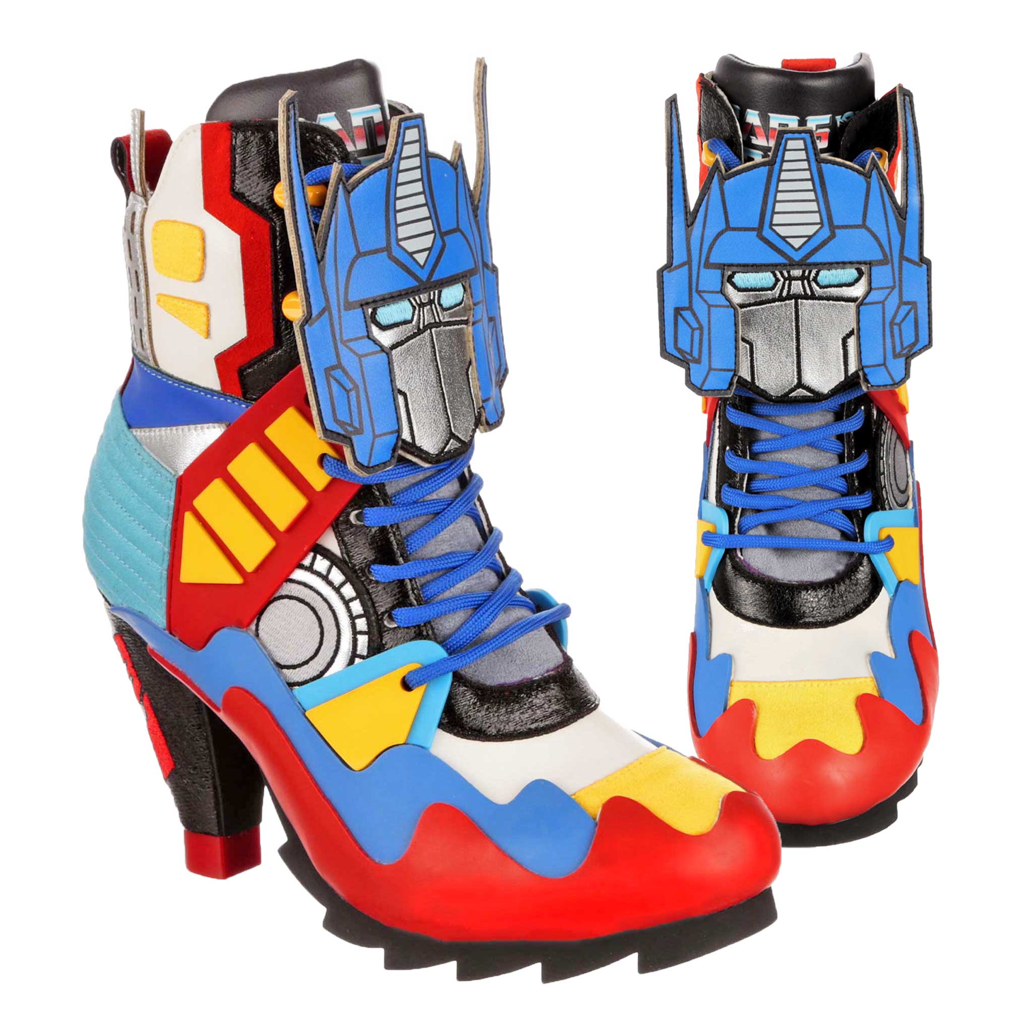 A pair of multicoloured Transformers-themed sporty style high heeled boots. Blue, red, yellow and white geometric shapes make up most of these ankle boots with a chunky black platform and high heel. Blue laces lace up the heeled boot with a large Optimus Prime decal sitting on the laces.  A black tongue is poking out the top with the Transformers logo showing partially.   