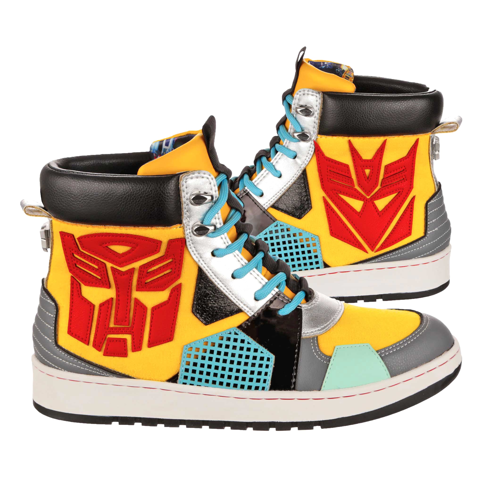 A pair of multicoloured high top trainers sitting side by side with a white chunky sole. Transformers themed flat trainers with yellow, grey and black geometric shapes sit facing side on. A red Decepticon and Autobot label sit either side of these lace-up trainers. Blue laces tread through the silver eyelets of the trainer whilst a black chunky trim sits at the top of the trainer boot.